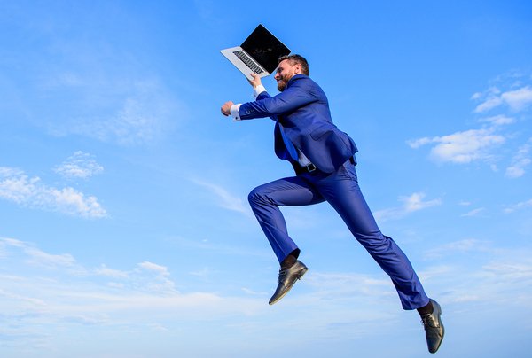 Man leaping in the sky with a laptop.