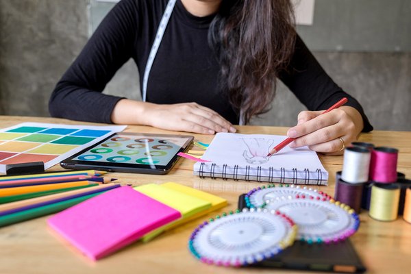 Fashion designer drawing in a sketch book.