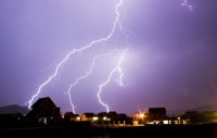 Residential neighborhood at night with lightening strikes. Quantum Innovation