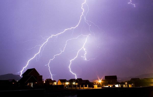 Residential neighborhood at night with lightening strikes.